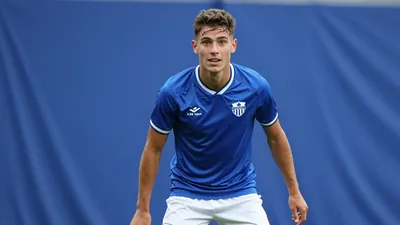 A photorealistic image of an anonymous 20-year-old central defender of Jong KAA Gent, wearing a blue jersey and white...