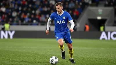 A photorealistic image of an anonymous Gent player in a blue jersey with white sleeves, yellow socks, and black boots...